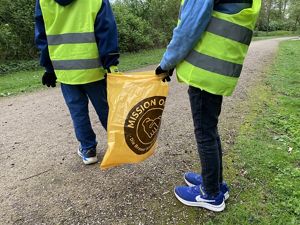 Kinder mit Warnwesten und Mülltüte